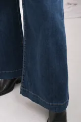 Jean de tiro alto y corte wide leg, confeccionado en denim azul oscuro con costuras en contraste.