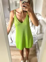 Vestido corto verde lima con breteles finos y escote en V.