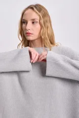Sweater gris de punto inglés con cuello redondo y mangas largas.