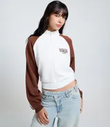 Saco femenino de poliviscosa, color blanco con mangas raglán marrones y ribetes blancos. Tiene cuello alto, cierre frontal de cremallera y bordado lettering "Kansas City" en el pecho.