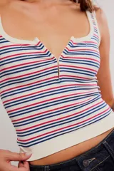 Musculosa acanalada de corte ajustado y corto, con estampado de rayas horizontales en tonos azules y rojos sobre base blanca. Presenta escote cuadrado con abertura frontal y tirantes anchos.