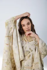 Vestido corto con estampado de hojas en tonos beige y amarillo, sin mangas y escote redondo. Incluye un poncho a juego con el mismo estampado.