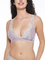Bralette de encaje color lila con detalles en color crema, diseño triangular sin aros y banda elástica inferior.