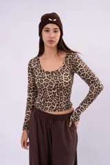 Remera de manga larga con estampado animal print de leopardo, corte cropped y escote redondo pronunciado.