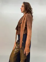 Buzo de punto confeccionado en 100% lana merino con efecto degradé en tonos azules. Presenta un diseño versátil con lazos largos que nacen de la cintura alta para anudar de diferentes formas, mangas entalladas con ojal para el pulgar y cuello redondo.