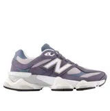 Championes New Balance modelo 9060, con diseño futurista inspirado en la estética de los años 2000. Presenta una combinación de tonos grises y azulados, con una entresuela esculpida de líneas onduladas y proporciones marcadas que integran tecnologías de amortiguación para mayor confort.