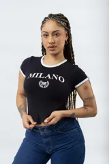 Remera ajustada de manga corta color marrón oscuro, con cuello redondo y ribetes blancos en el cuello y mangas. Presenta un estampado frontal en blanco con el texto "MILANO" y un escudo con el número "96".