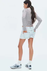 Remera ajustada de punto acanalado, color blanco con rayas finas bordó. Tiene cuello redondo con ribete de picot y tapeta de botones en la parte delantera.