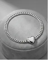 Collar de cadena de eslabones tipo barbada con dije central en forma de corazón liso.