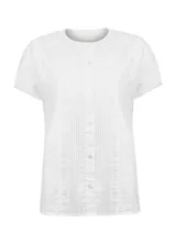 Blusa blanca de algodón orgánico con cuello redondo, manga corta abullonada y cierre frontal con botones. Presenta delicados bordados, pliegues y calados en la parte superior.