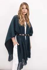 Ruana de tejido de punto en color verde oscuro, con diseño abierto, textura elástica y terminación con flecos en el ruedo.
