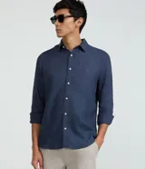 Camisa de lino puro color azul marino, de corte confort, con cuello inglés, manga larga y abotonado delantero con botones blancos contrastantes.