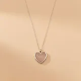 Collar de cadena fina de plata con dije en forma de corazón que contiene una piedra de cuarzo rosa en su interior.