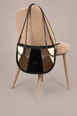 Cartera bandolera de diseño semiesférico, combinada en tonos negro, marrón y beige, confeccionada en cuero con paneles texturizados y gamuza en el centro. Cuenta con correa de cadena y tiras de hombro, además de cierre superior.