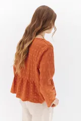 Camisa color crema con bordados florales, escote en V, mangas largas y cierre frontal con botones.