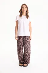 Blusa de manga corta con pliegues en escote redondo, confeccionada en tela crepé de color beige.
