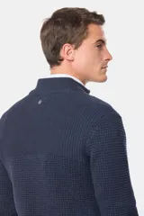 Buzo tejido azul marino con cuello alto y medio cierre frontal. Presenta una textura estructurada y manga larga.