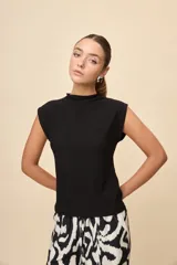 Top de calce entallado, sin mangas y con cuello alto, confeccionado en tejido texturado de líneas simples.