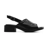 Sandalia de cuero sintético color negro, con taco cuadrado bajo, tira ancha sobre el empeine y pulsera al tobillo con hebilla metálica.