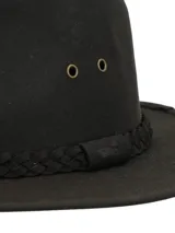 Sombrero tipo fedora de canvas engrasado impermeable, color verde oliva, con detalle de cinta trenzada decorativa y ojales metálicos de ventilación.