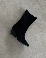 Botas de caña media color negro, confeccionadas en gamuza, con punta fina y taco geométrico.