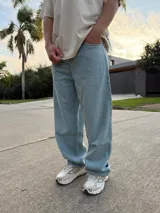 Pantalón de jean estilo baggy, de corte holgado y tiro medio, confeccionado en denim de tela pesada en tono celeste claro.
