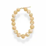 Collar corto compuesto por esferas de resina en tonos beige con efecto marmolado. Cuenta con cierre de mosquetón y cadena de alargue metálica en tono dorado.