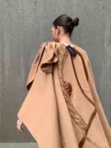 Capa color camel de tejido de punto en lana, con apliques de cuero en el hombro.