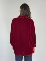 Camisa verde oscuro de terciopelo de viscosa, con cuello mao, corte recto, mangas largas abullonadas y cierre frontal con botones.