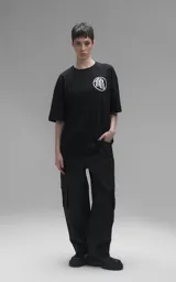 Remera negra de corte oversize con estampa frontal de Goku niño sobre la nube voladora rodeado de esferas del dragón.