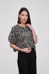 Blusa de algodón con estampado animal print tipo cebra, cuello redondo y mangas cortas abullonadas con diseño de globo.