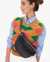 Riñonera negra tejida con correa de cuero ajustable y cadena de eslabones grandes de acrílico.