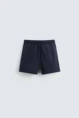 Bañador de hombre color azul marino, confeccionado en tejido técnico, con cintura elástica ajustable mediante cordón. Presenta bolsillos laterales y un bolsillo trasero de plastrón. Incluye forro interior.