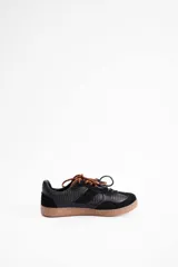 Championes de cuero vacuno negro con diseño de paneles texturizados, cordones dobles en color marrón y suela de goma color caramelo.