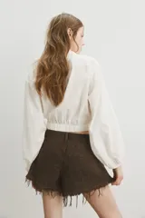 Short de cinco bolsillos en denim de algodón rígido, de tiro alto con cierre y botón, corte holgado y bajo deshilachado.