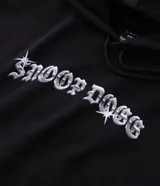 Buzo con capucha de algodón con forro polar, diseño de manga larga con puños y bajo elásticos, y bolsillo tipo canguro. Presenta un estampado gráfico en la espalda con la imagen de Snoop Dogg y lettering estilo gótico.