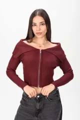 Sweater corto de tejido acanalado en color bordó, con cuello tipo off-shoulder solapado y cierre frontal completo con cremallera.