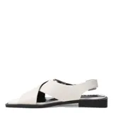 Sandalias chatas de diseño minimalista con tiras cruzadas en el empeine y cierre con hebilla metálica lateral. Presentan una suela plana de color negro y puntera cuadrada.