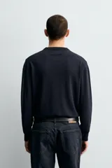 Jersey de corte regular fit, tejido en lana de origen italiano, con cuello redondo y manga larga. Presenta acabados en rib en puños y ruedo.