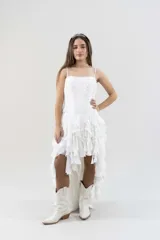 Vestido blanco de gasa con corsé drapeado y bordado con canutillos y piedras tornasoladas. Falda de volados irregulares con terminación asimétrica.