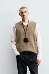 Chaleco regular fit de punto tejido en hilatura con mezcla de lana, color marrón con efecto melange. Cuenta con cuello en V y manga sisa, con acabados acanalados.