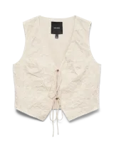 Chaleco color beige con diseño bordado, escote en V y cierre frontal con finos lazos para atar.