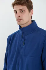 Campera de micropolar color verde oscuro, con cuello alto, cierre frontal completo, bolsillos laterales y un bolsillo con cierre en el pecho.