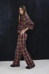 Pantalon de corte sastrero con estampado de cuadros escoceses en tonos marrones, bordo y blanco. Presenta tiro medio, bolsillos laterales con detalle de vivo en color bordo y pretina en material símil gamuza al tono.
