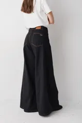 Pantalón de jean azul de tiro alto y corte wide leg súper amplio, con diseño de perneras ancha y terminación desmechada en el ruedo.