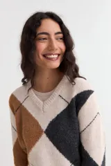 Sweater de punto con diseño de rombos en tonos gris, marrón y negro, con cuello en V y mangas largas.