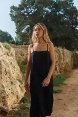 Vestido midi de lino y rayón, color negro, con escote recto, tirantes finos ajustables y tajo lateral.