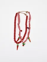 Collar doble de cuentas rojas y tiras de tela a cuadros vichy, con dijes colgantes de chiles y zanahorias.