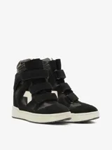 Zapatilla de caña alta, color blanco hueso, con cierre de tres tiras de velcro. Presenta recortes en gamuza y paneles acolchados en el lateral, con suela de goma gruesa.