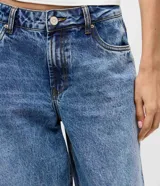 Pantalón wide leg de tiro bajo confeccionado en denim de algodón. Presenta un diseño de pierna amplia con ruedo doblado, cintura con pasadores y cierre frontal con botón y cremallera.